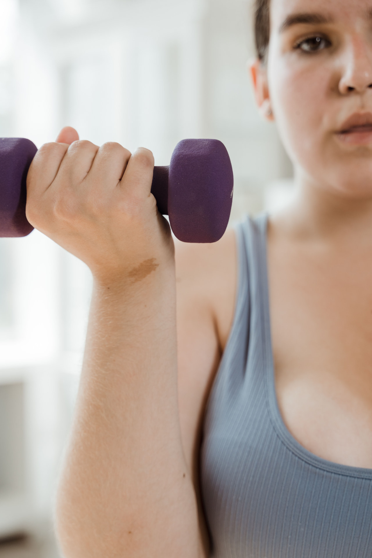 Woman exercising with a dumbbell at home